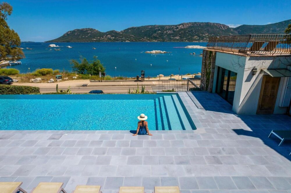 Piscine avec vue mer et montagnes.