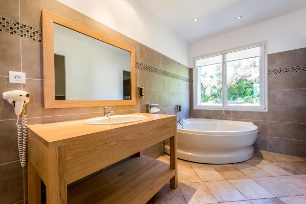 Salle de bain moderne avec baignoire et miroir.