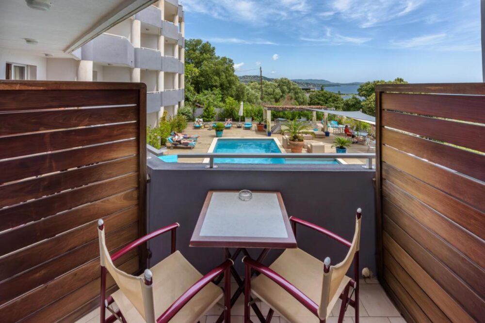 Balcon avec vue sur piscine et jardin luxuriant.