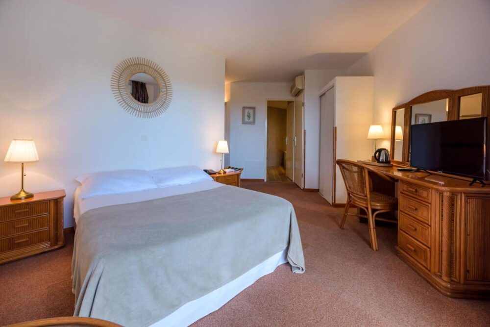 Chambre d'hôtel confortable avec miroir et bureau.