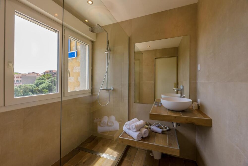 Salle de bain moderne avec douche et lavabo.