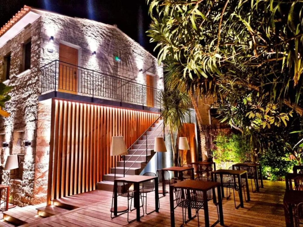 Terrasse extérieure éclairée la nuit avec meubles modernes.