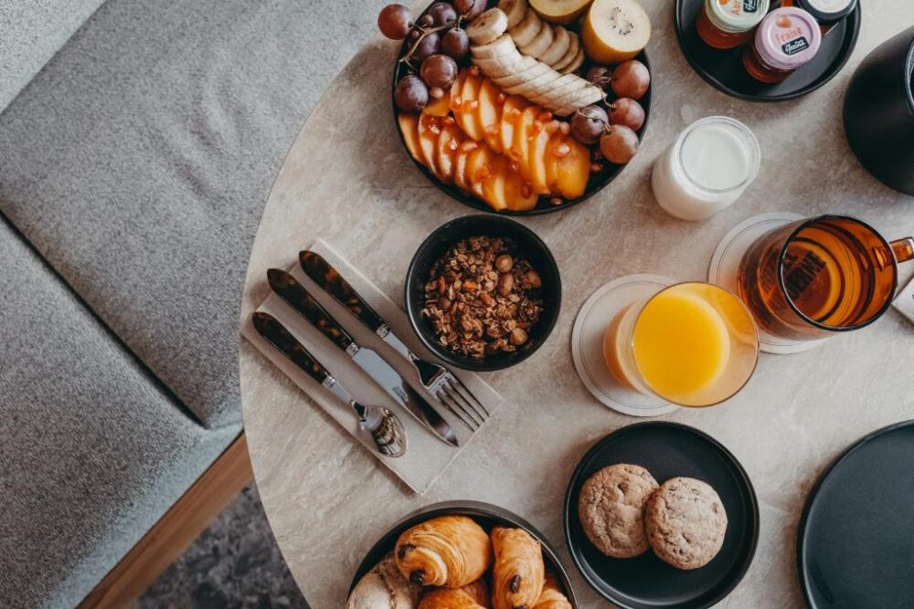 Petit-déjeuner avec fruits, jus et viennoiseries.