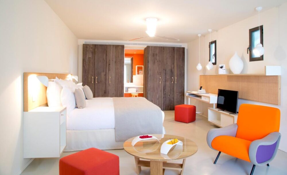 Chambre moderne avec fauteuil orange et déco élégante