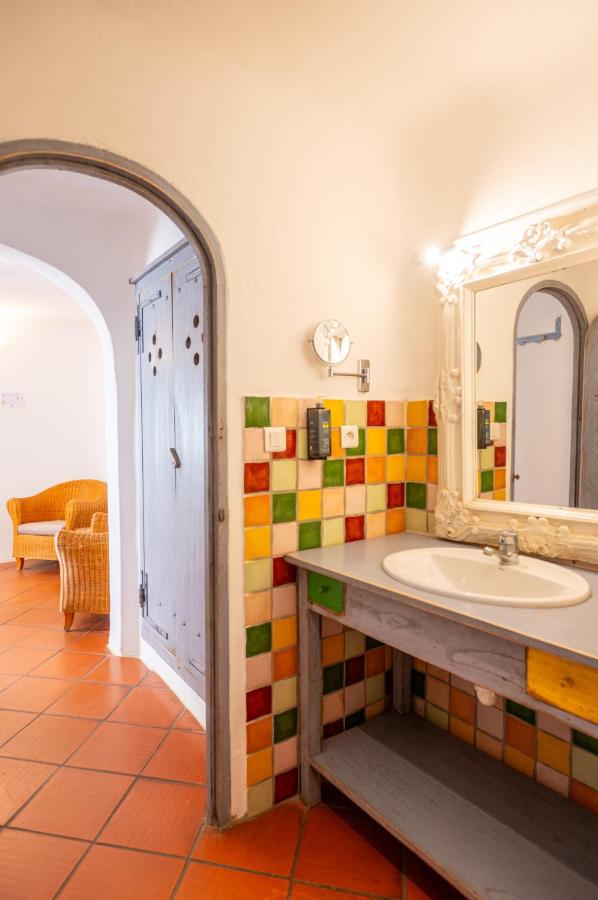 Salle de bain colorée avec miroir et lavabo.