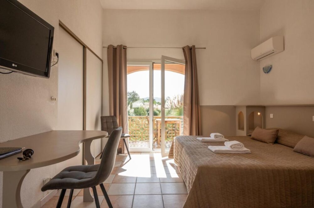 Chambre d'hôtel avec lit double et balcon.