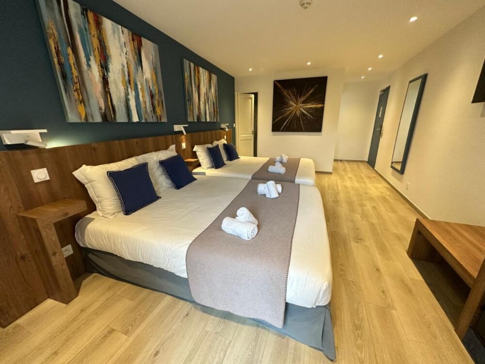 Chambre d'hôtel moderne avec deux lits.