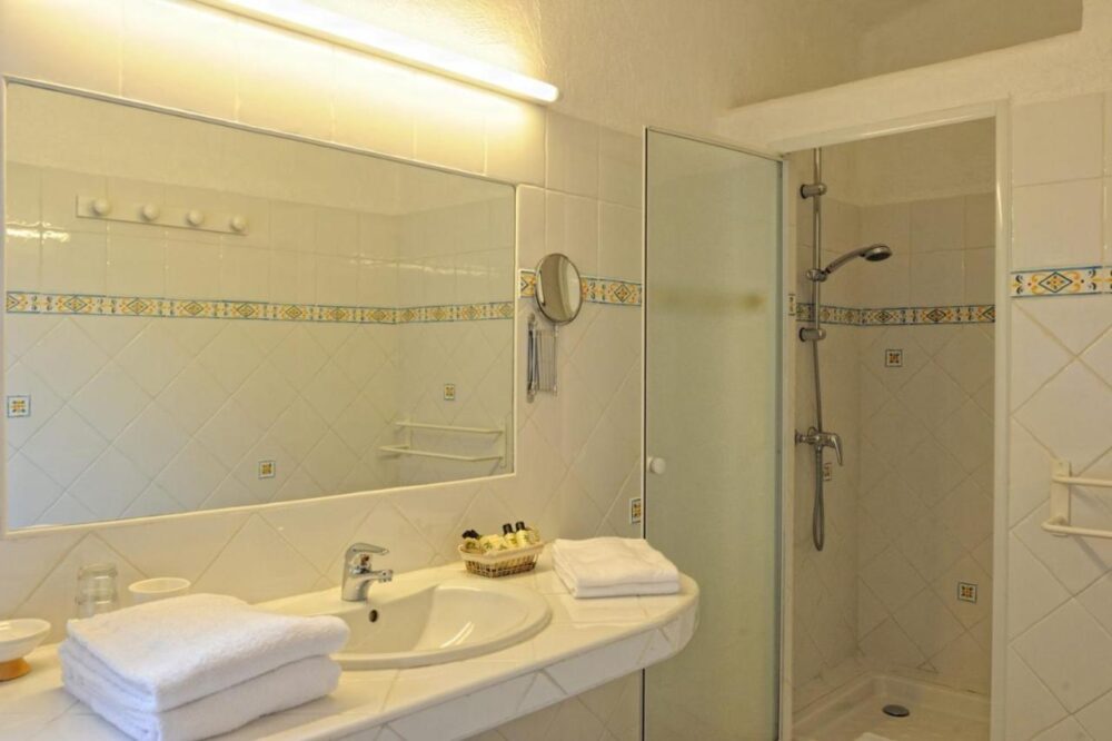 Salle de bain moderne avec douche et miroir.