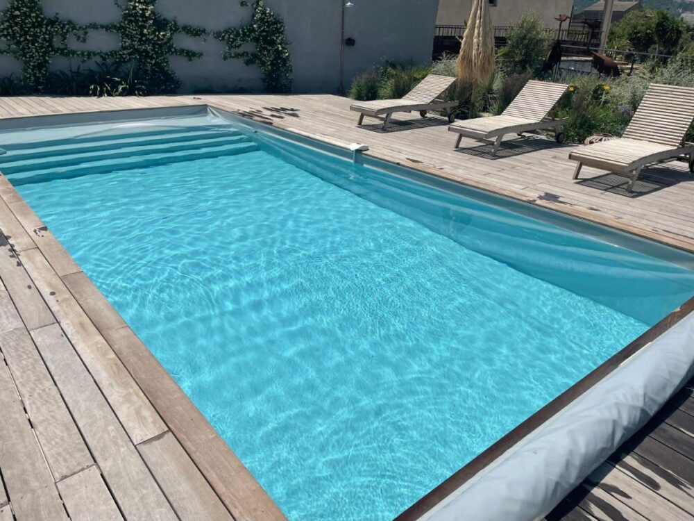 Piscine extérieure avec terrasses en bois.