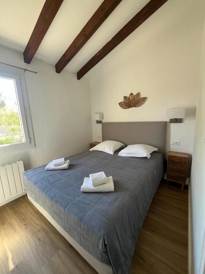 Chambre avec grand lit et poutres apparentes.