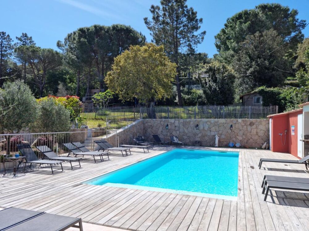 Piscine extérieure entourée de chaises longues.