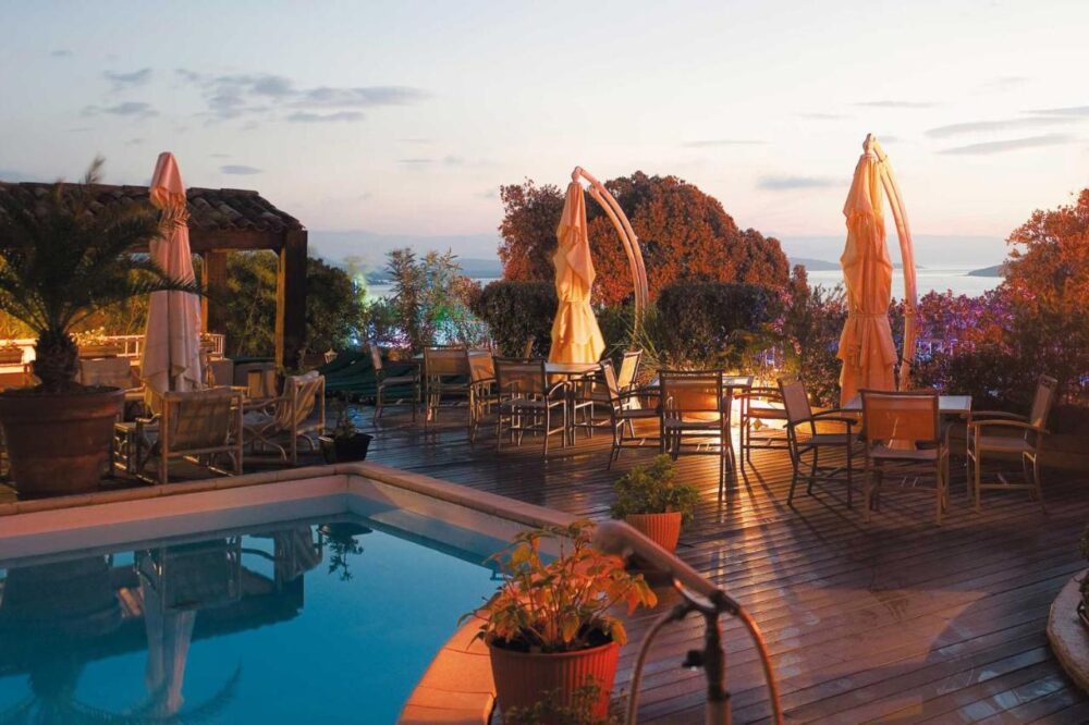 Terrasse au bord de la piscine au coucher du soleil.