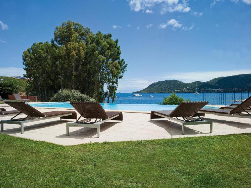 Transats près d'une piscine avec vue mer.
