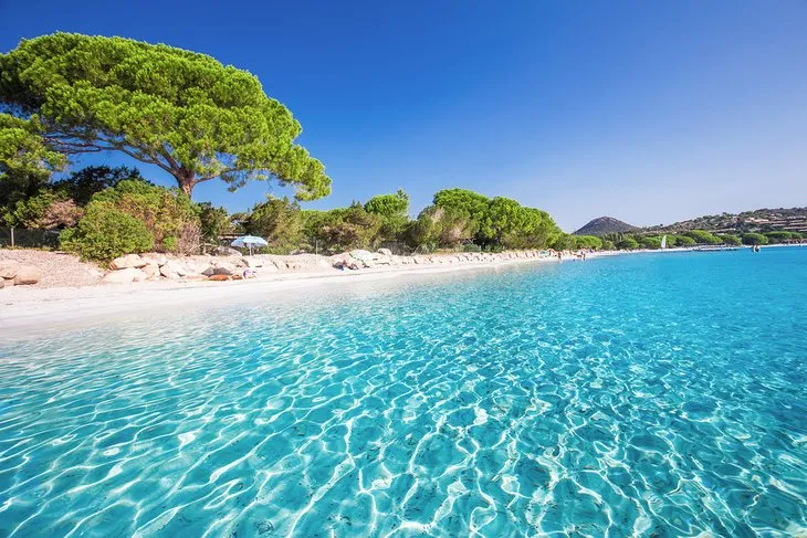 Plage avec sable blanc et eau turquoise.