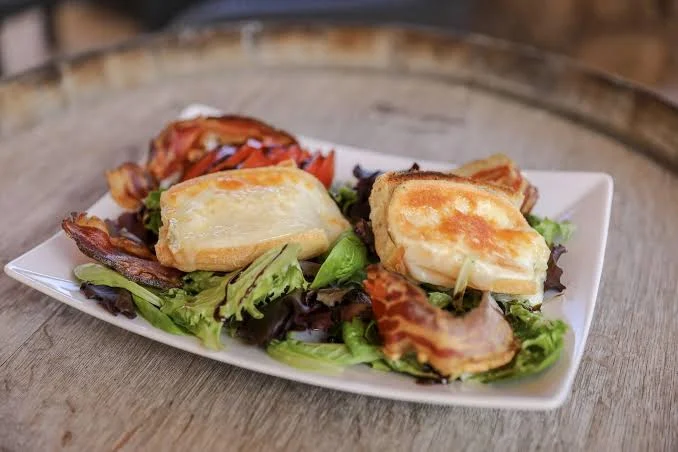 Salade avec fromage chaud et bacon.
