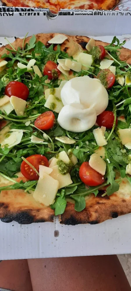 Pizza avec roquette, tomates, fromage et burrata.