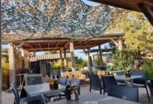 Terrasse extérieure avec tables et chaises sous abri.