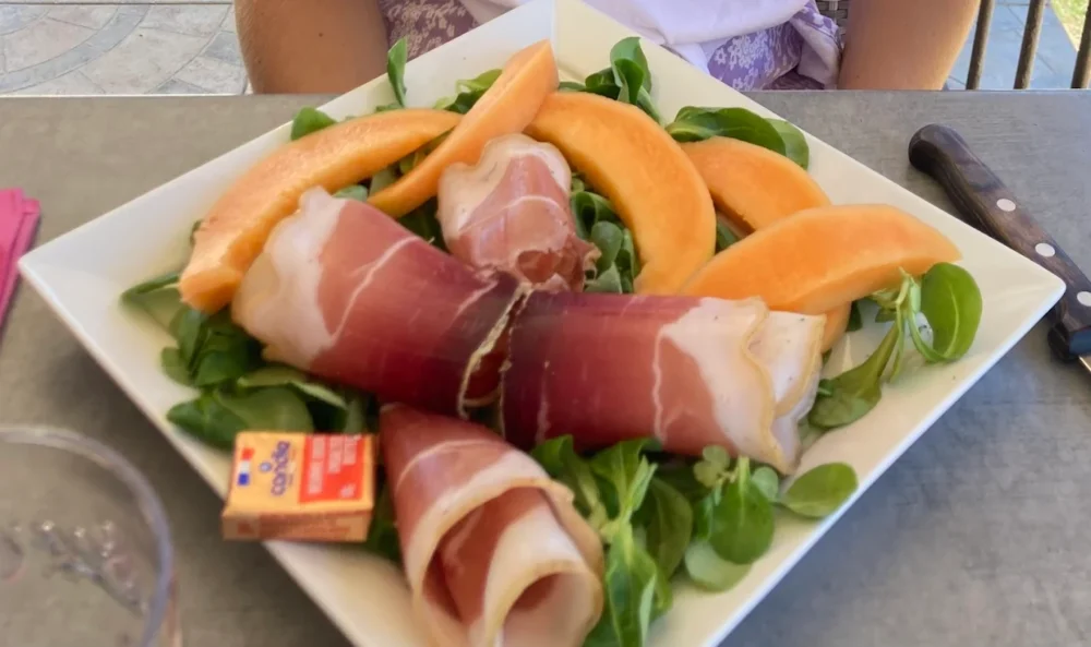 Assiette de melon, jambon cru et salade.