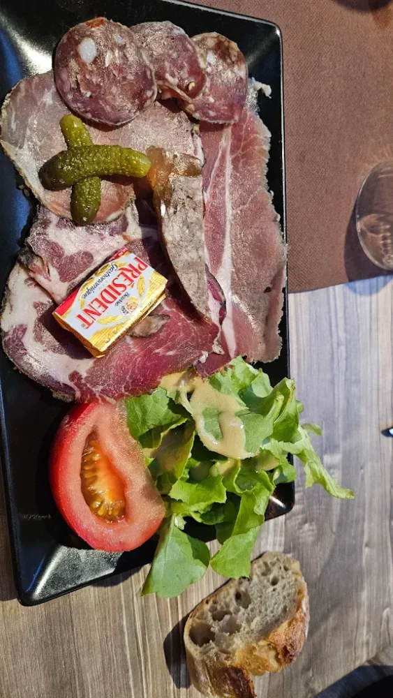 Assiette de charcuterie avec salade et pain.