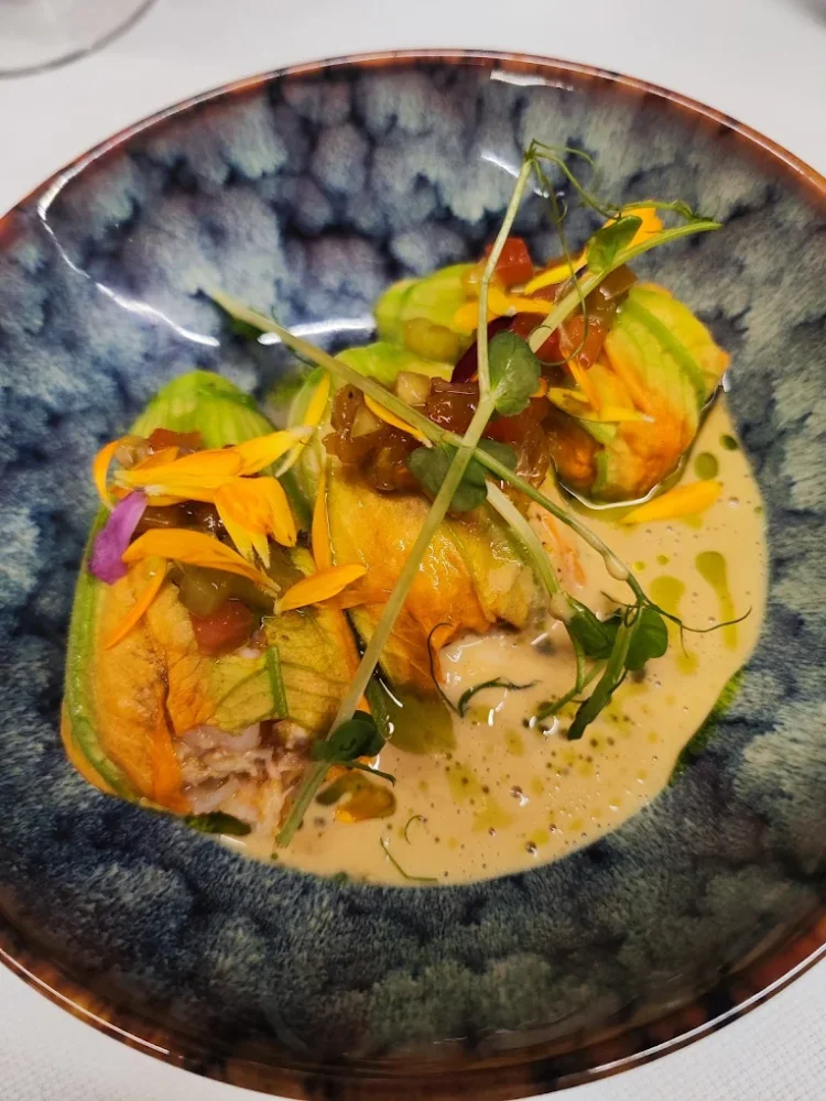 Fleurs de courgettes farcies dans une assiette gastronomique.