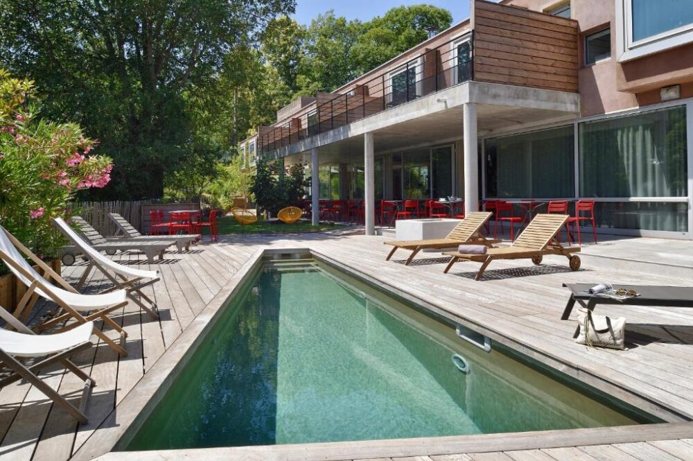 Terrasse moderne avec piscine et chaises longues.