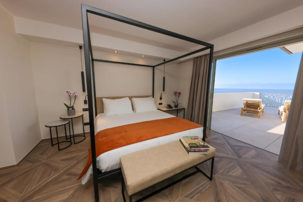 Chambre moderne avec vue mer et terrasse.