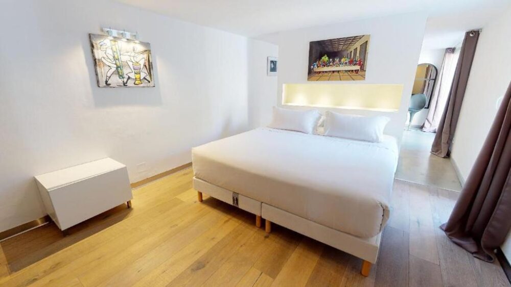 Chambre moderne avec lit double et tableau lumineux.