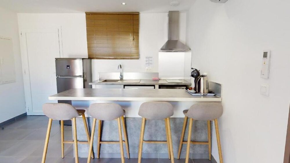 Cuisine moderne avec îlot et tabourets.