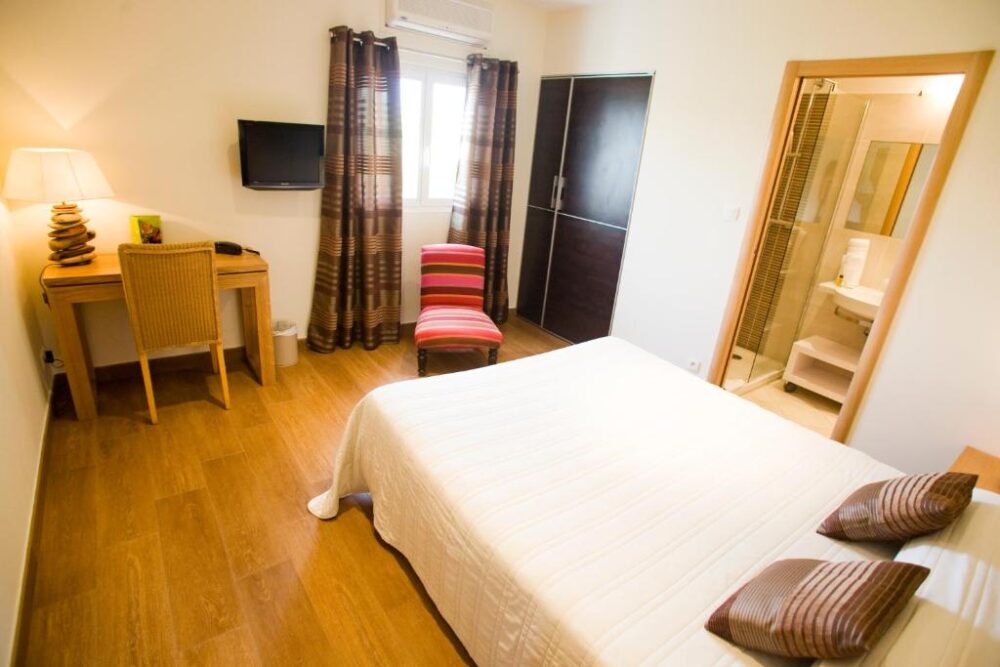 Chambre d'hôtel lumineuse avec salle de bain attenante.