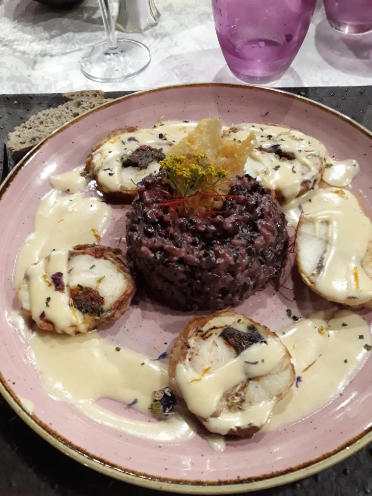 Plat gourmet avec viande et risotto noir.